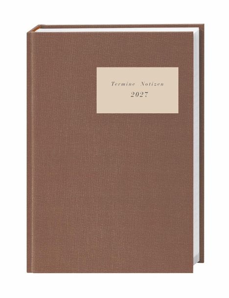 Brauner Kalender mit der Aufschrift "Termine Notizen 2027" auf einem cremefarbenen Etikett.