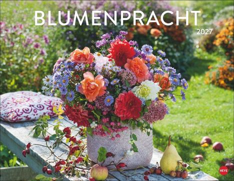 Text: "BLUMENPRACHT 2027." 

Beschreibung: Bunter Blumenstrauß auf Tisch, umgeben von grüner Wiese mit verstreutem Obst.