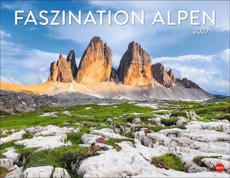 "FASZINATION ALPEN 2027". Eine Berglandschaft mit grüner Wiese, Felsen und markanten, sonnenbeschienenen Gipfeln.