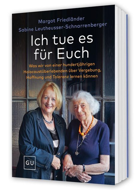 "Ich tue es für Euch". Zwei lächelnde ältere Frauen stehen Seite an Seite.