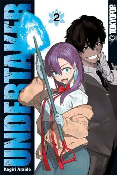 „UNDERTAKER“, „2“, „Kagiri Araido“. Zwei Personen, eine Frau mit Kehrschaufel lächelt, ein Mann steht dahinter.