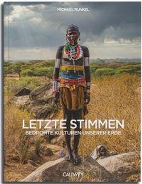 "LETZTE STIMMEN Bedrohte Kulturen unserer Erde." Ein farbenfroh gekleideter Mensch steht in einer trockenen Landschaft.