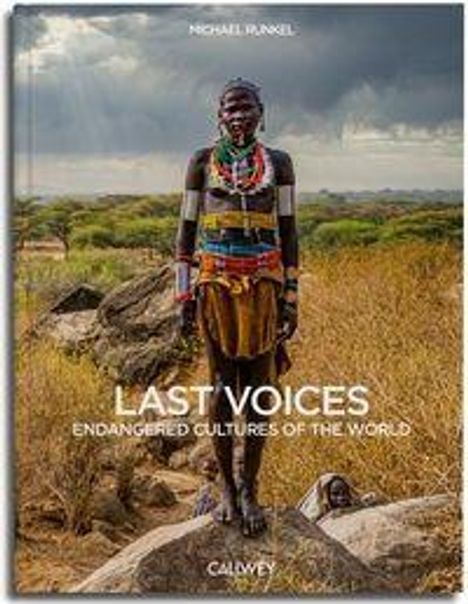 LAST VOICES: ENDANGERED CULTURES OF THE WORLD. CALMEY. Person in traditioneller Kleidung steht in einer Savannenlandschaft.