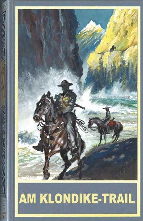 "AM KLONDIKE-TRAIL" steht unten. Zwei Reiter durchqueren eine stürmische, wilde Landschaft mit Bergen im Hintergrund.