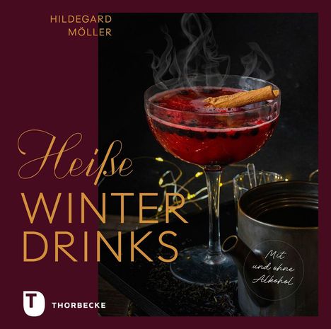 „Heiße Winterdrinks“. Ein Getränk in einem Glas mit Zimtstange, umgeben von Lichtern.