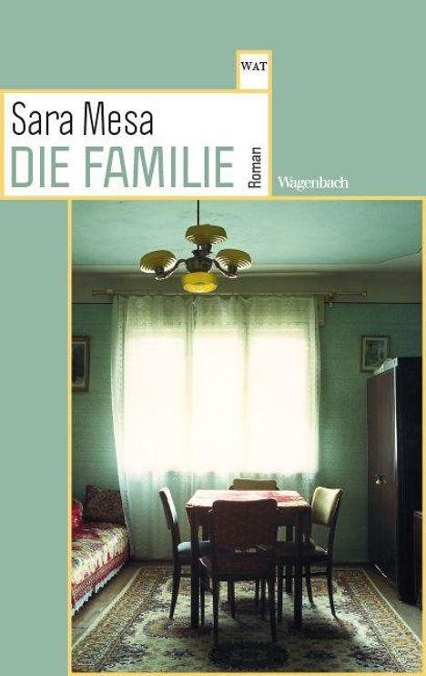 Text: "Sara Mesa – DIE FAMILIE – Roman". Ein schlicht eingerichteter Raum mit Tisch, Stühlen, Sofa und einem großen Fenster.