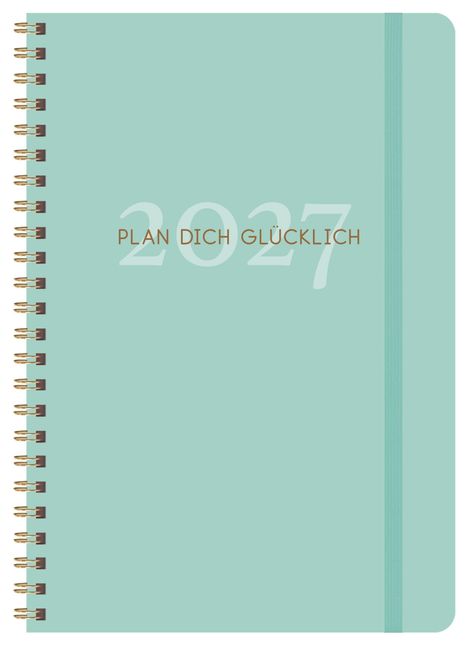 „2027“ und „PLAN DICH GLÜCKLICH“ auf hellgrünem Spiralbuch, elastisches Band rechts.