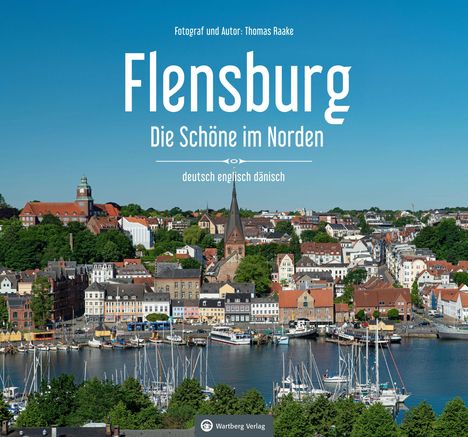 Flensburg: Die Schöne im Norden. Stadtansicht mit Hafen, Segelbooten, Kirche, roten Dächern und grünem Wald im Hintergrund.