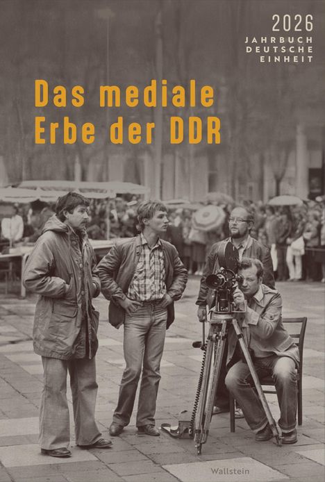 „Das mediale Erbe der DDR“, Jahrbuch Deutsche Einheit 2026; Männer mit Kamera in Schwarz-Weiß, im Hintergrund ein Marktplatz.