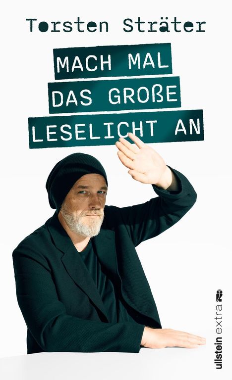 "Torsten Sträter. Mach mal das große Leselicht an." Ein Mann mit Mütze hebt die Hand, als ob er sich vor Licht schützt.