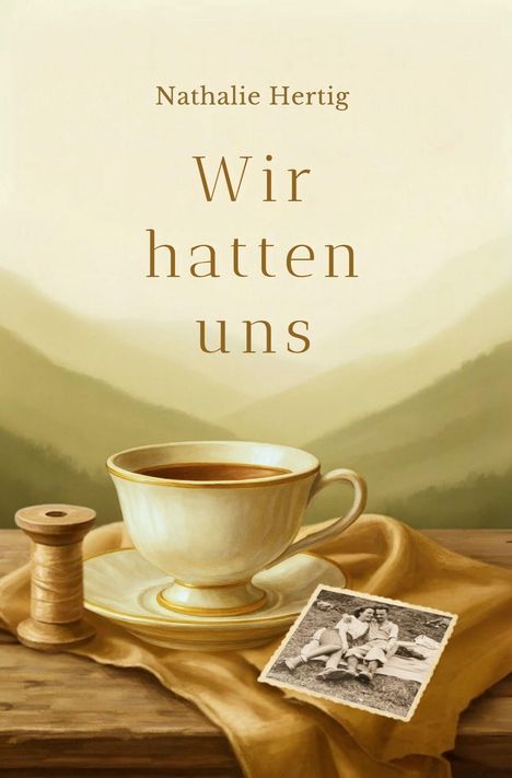 „Nathalie Hertig - Wir hatten uns“. Eine Tasse Kaffee, Garnrolle und altes Foto auf Holzuntergrund vor Berglandschaft.