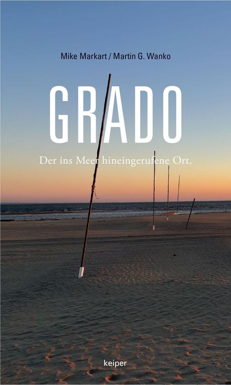 "GRADO - Der ins Meer hineingerufene Ort." Strand bei Sonnenuntergang, mehrere aufgestellte Stangen im Sand.