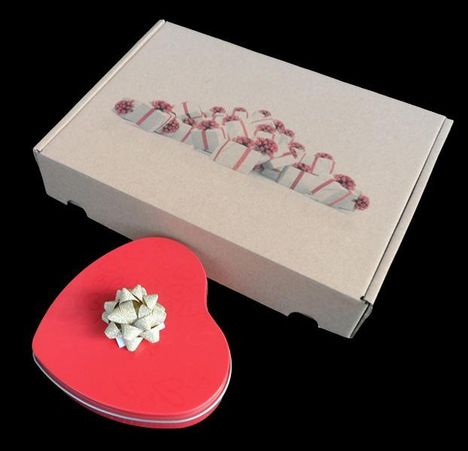 Ein brauner Karton mit Geschenkillustration daneben eine rote herzförmige Box mit goldener Schleife.
