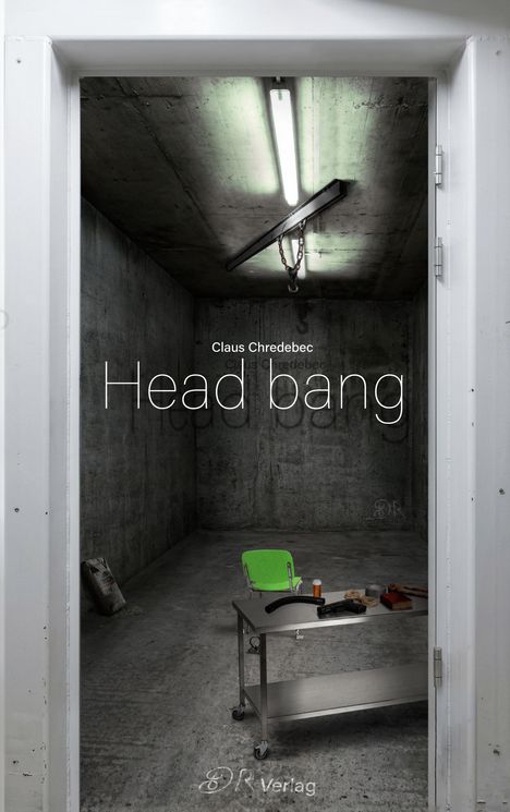„Claus Chredebec, Head bang“ ist zu lesen. Ein kahler, grauer Raum mit grünem Stuhl und Metalltisch.