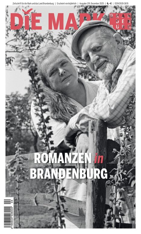 „ROMANZEN in BRANDENBURG“. Ein älteres Paar lehnt an einem Holzzaun umgeben von Bäumen.