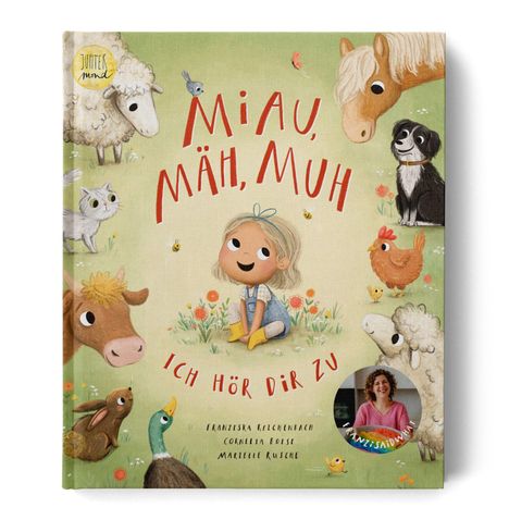 „Miau, Mäh, Muh. Ich hör dir zu.“ Ein Mädchen sitzt inmitten von Tieren wie Schaf, Hund, Katze und Ente auf einer Wiese.