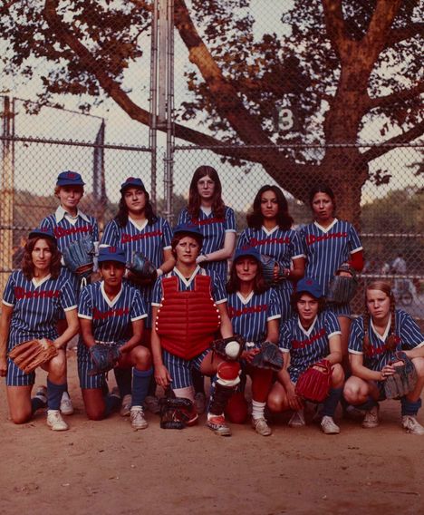Mehrere Menschen in blau-weiß gestreiften Uniformen mit roten Schriften, auf einem Baseballfeld.