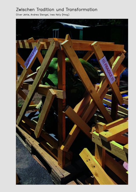 "Zwischen Tradition und Transformation", Autoren: Oliver Jehle, Andrea Stengel, Ines Kelly; zerbrechliche Statue in Holzkiste.
