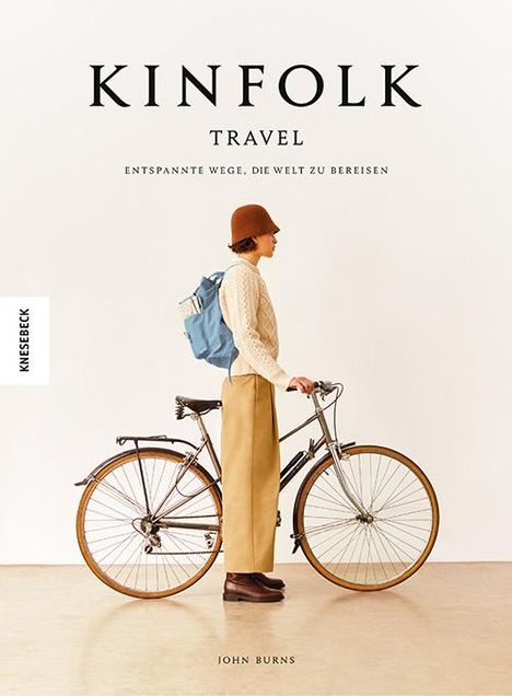 KINFOLK TRAVEL: Entspannte Wege, die Welt zu bereisen. Ein Mann mit blauem Rucksack neben einem Fahrrad.