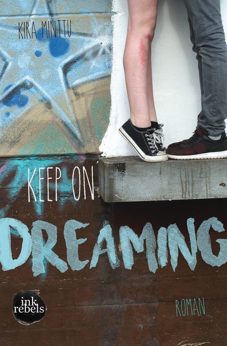 Text: "KIRA MINTTU", "KEEP ON DREAMING", "ink rebels", "ROMAN." Zwei Personen stehen nah beieinander, Graffiti im Hintergrund.