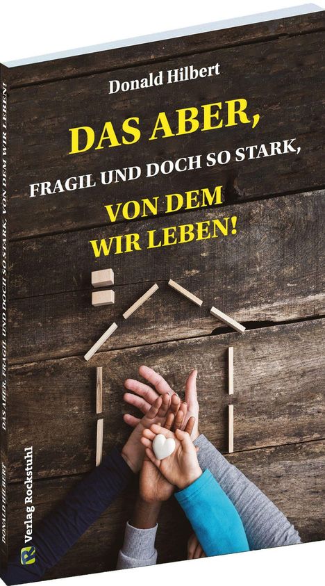 "Donald Hilbert: DAS ABER, FRAGIL UND DOCH SO STARK, VON DEM WIR LEBEN!" Hände halten ein Herz, auf Holzuntergrund.