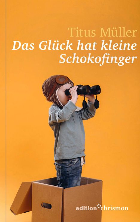 „Titus Müller: Das Glück hat kleine Schokofinger.“ Ein Kind mit Fliegermütze schaut mit einem Fernglas aus einem Karton.