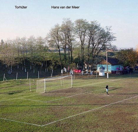 "Torhüter Hans van der Meer." Eine Person steht auf einem Fußballplatz vor einem Tor. Bäume und ein kleines Haus im Hintergrund.