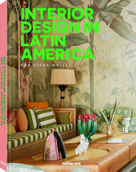 "INTERIOR DESIGN IN LATIN AMERICA" in Grün. Gemütliches Wohnzimmer mit gemusterten Kissen, Tischdeko und Pflanzenmotiven an der Wand.
