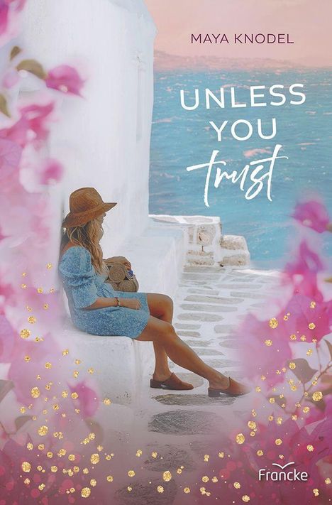 "Maya Knodel. Unless You Trust." Eine Frau sitzt mit Strohhut an einer weißen Wand, umgeben von rosa Blüten und blauem Meer.