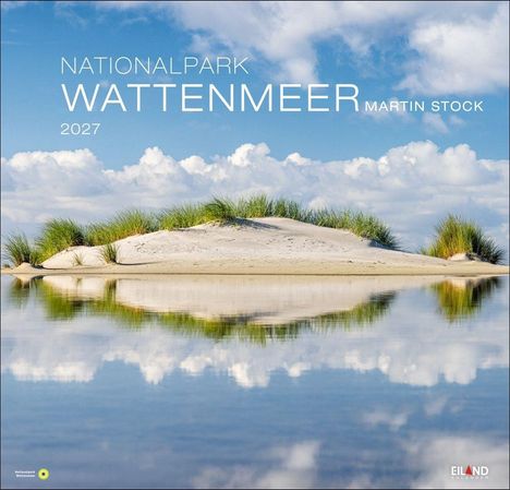 NATIONALPARK WATTENMEER 2027, Martin Stock. Sanddüne mit Gras, blauer Himmel, weiße Wolken, Spiegelung im Wasser.