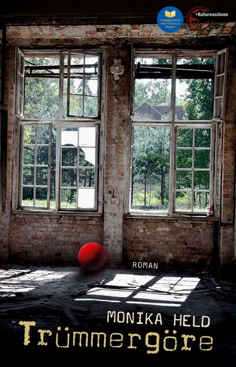 Text: "Monika Held, Trümmergöre, Roman". Alte Backsteinwände, Fenster mit Blick auf grüne Bäume, roter Ball im Raum.