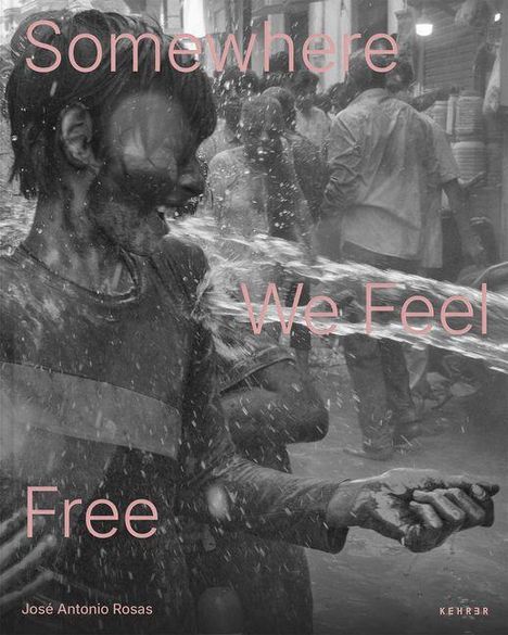 Text: "Somewhere We Feel Free". Ein lachendes Kind spielt im Wasserstrahl auf einer belebten Straße.