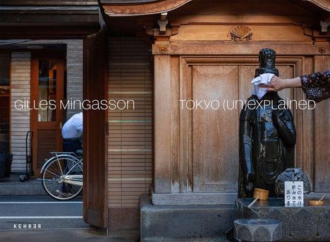 Texte: "Gilles Mingasson", "Tokyo (un)explained". Eine Hand reinigt eine Statue neben einem traditionellen Holztor.