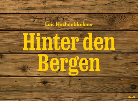 Gelber Text "Lois Hechenblaikner" und "Hinter den Bergen" auf Holzmaserung, unten "Steidl".