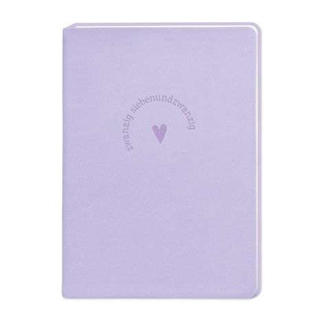 Der Text "zwanzig siebenundzwanzig" kreisförmig um ein Herz auf einem fliederfarbenen Notizbuch.