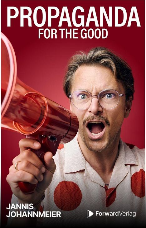 „PROPAGANDA FOR THE GOOD.“ Mann mit Megafon, trägt Brille und Hemd mit roten Punkten.