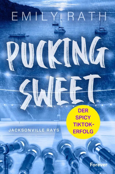 "PUCKING SWEET", gelbe Plakette "DER SPICY TIKTOK-ERFOLG", Eishockey-Spielfeld, Mikrofone im Vordergrund.