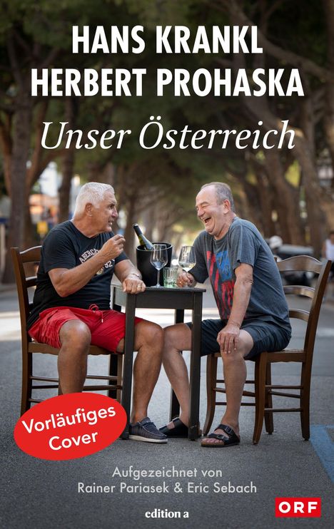 Zwei Männer lachen bei einem Glas Wein an einem Tisch auf einer von Bäumen gesäumten Straße. Texte: „Hans Krankl“, „Herbert Prohaska“, „Unser Österreich“, „Vorläufiges Cover“.