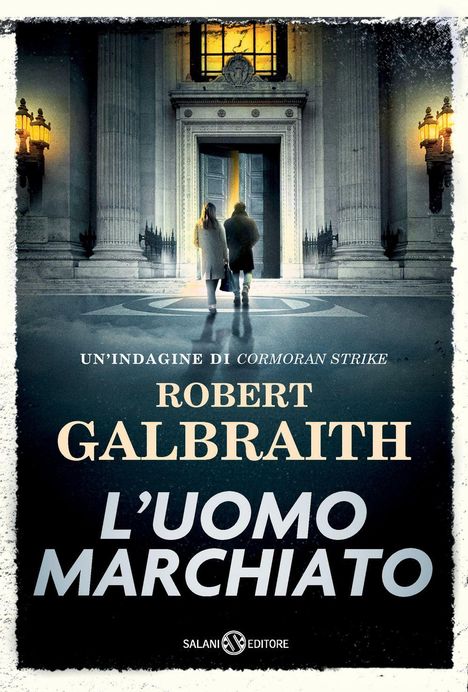 "Un'indagine di Cormoran Strike." Zwei Personen betreten eine große, eindrucksvolle Eingangstür eines Gebäudes.
