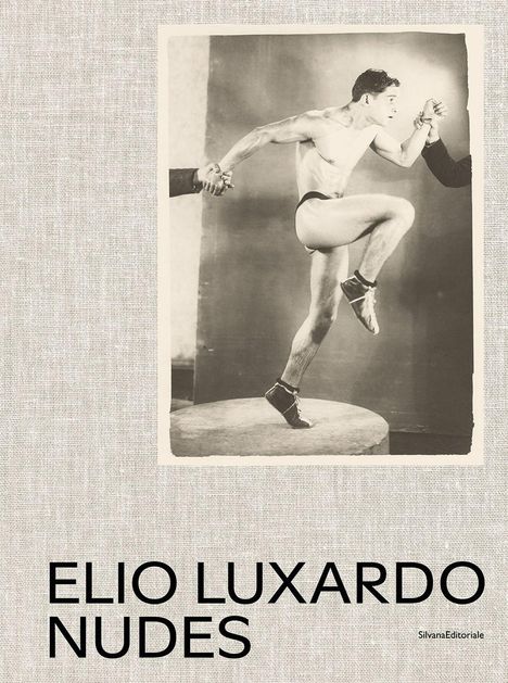 Text: "ELIO LUXARDO NUDES". Schwarz-weiß Foto eines springenden, leicht bekleideten Mannes, gehalten von zwei Händen.