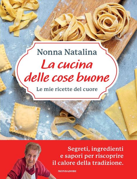 „La cucina delle cose buone“ steht auf einem Kochbuch-Cover, umgeben von frischer Pasta und einer älteren Frau in Schürze.