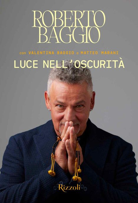 Text: "ROBERTO BAGGIO", "Luce nell’oscurità". Mann mit gefalteten Händen, blauem Anzug, betende Haltung, Lächeln.
