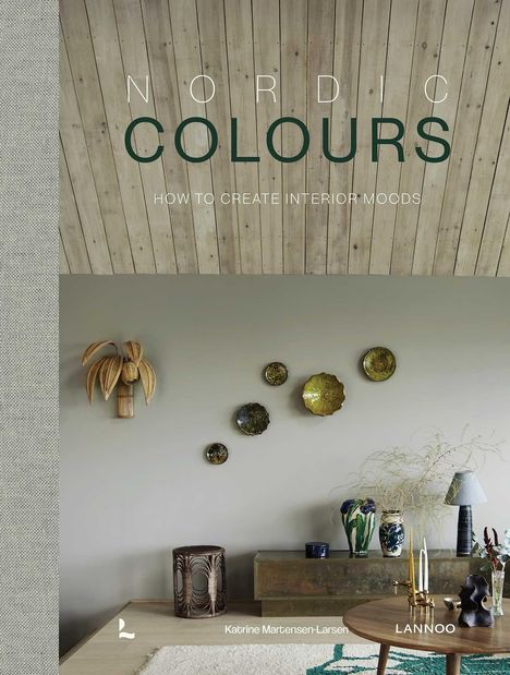 "NORDIC COLOURS: HOW TO CREATE INTERIOR MOODS." Rustikaler Raum mit Holzdecke, Dekor an der Wand, Vasen und Pflanzen.