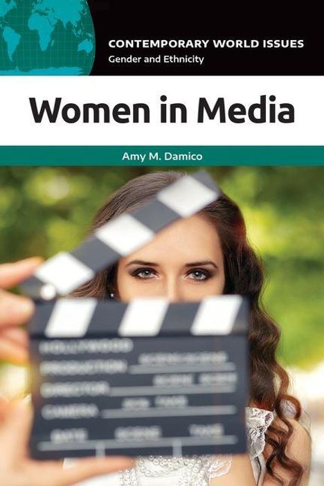 Women in Media. Amy M. Damico. Eine Frau hinter einer Filmklappe, bereit für eine Aufnahme.
