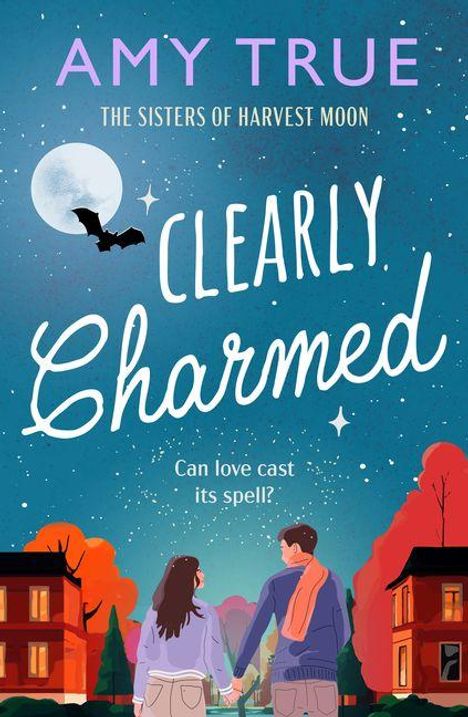 Der Text „Amy True“, „The Sisters of Harvest Moon“, „Clearly Charmed“, „Can love cast its spell?“. Ein Paar hält sich unter einem Sternenhimmel an den Händen.