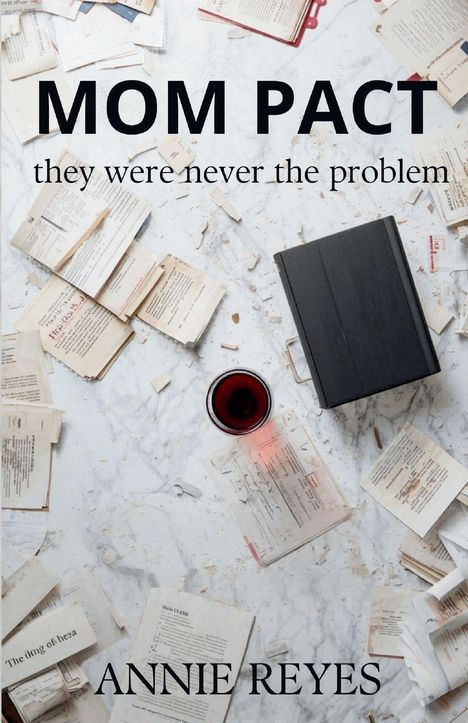 Texte: "MOM PACT", "they were never the problem", "ANNIE REYES". Bücher und ein Glas Wein auf Marmoruntergrund.