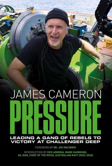 JAMES CAMERON PRESSURE; Mann in schwarzem Shirt und Mütze lacht in einer technischen Umgebung.
