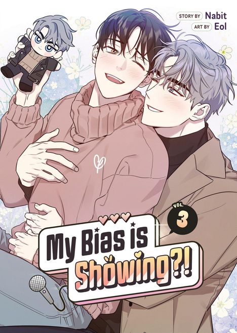 "My Bias is Showing?! Vol. 3" Text. Zwei lächelnde Personen, eine hält eine Plüschfigur. Es gibt Blumen im Hintergrund.