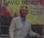 Der Text sagt: "DAVID BENOIT TIMELESS Featuring Spice Fusion Big Band". Ein Mann im Anzug lächelt vor einem bunten Hintergrund.