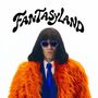 Text "FANTASYLAND" in geschwungener Schrift. Person mit dunklem Haar trägt orange Pelzmantel, blaue Brille und Krawatte.